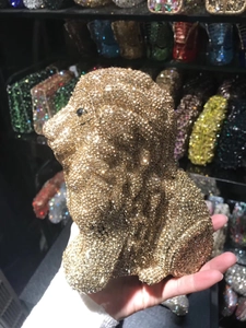 Close-up of golden lion-shaped evening clutch bag adorned with sparkling rhinestones