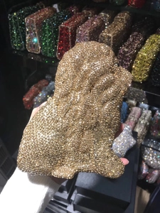 Close-up of a sparkling lion shaped evening clutch bag fully adorned with gold rhinestones