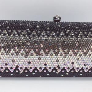 Macro shot of gradient crystal patterns and metal push lock on luxury evening clutch bag