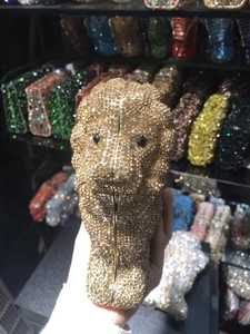 Detailed view of lion head clutch bag featuring gold crystal rhinestones and black eyes