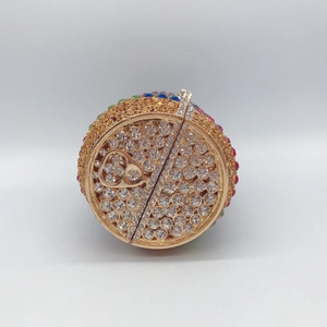 Makro-Detail einer Soda-Dose-Clutch mit bunten Kristallen und goldenem Ringgriff
