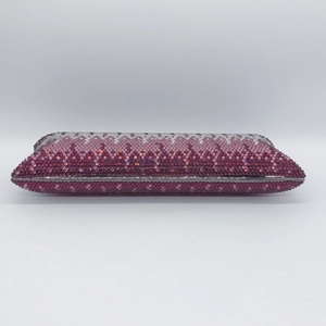Detail of evening clutch bag showing gradient purple and pink crystals in a wavy pattern