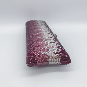 Close-up of a hard shell evening clutch bag with sparkling purple and pink rhinestones