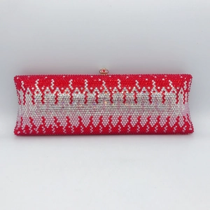 Macro shot of red and white rhinestones in wave patterns on a luxury evening clutch