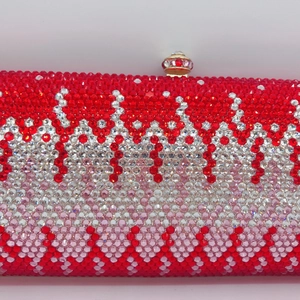 Close-up of luxury evening clutch with red and white rhinestones and a jeweled metal lock