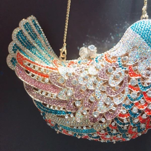 Close-up of bird-shaped evening bag with colorful crystals and gold chain strap