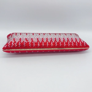 Macro side view of luxury evening clutch bag with red and silver wavy rhinestone pattern