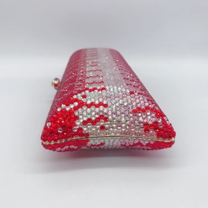 Macro side view of crystal evening clutch bag with red and pink gradient rhinestones