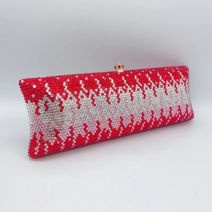 Macro view of luxury clutch with red and silver rhinestone wave pattern and metal clasp