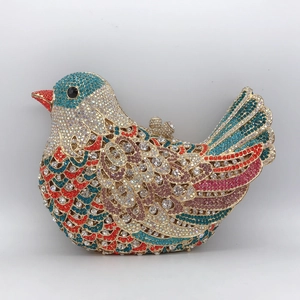 Detailed close-up of bird-shaped evening clutch bag with colorful rhinestones and gold clasp