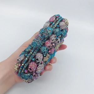 Luxe skull crystal clutch bag with colorful rhinestones held at a 45-degree angle