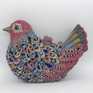 Macro detail of bird-shaped clutch with colorful rhinestones and feather texture