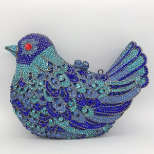 Macro shot of bird-shaped evening clutch with blue rhinestones and top ring closure