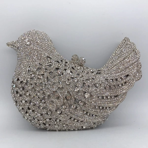 Macro shot of silver bird-shaped evening bag featuring dense crystal rhinestone pavé detail