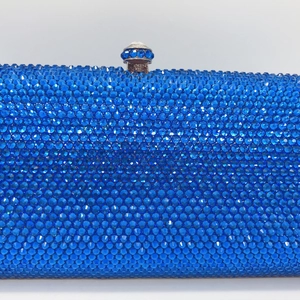Close-up of royal blue rhinestones and gemstone clasp on luxury evening clutch bag