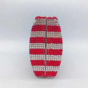 Macro shot of striped evening clutch bag with red crystals and silver metal clasp