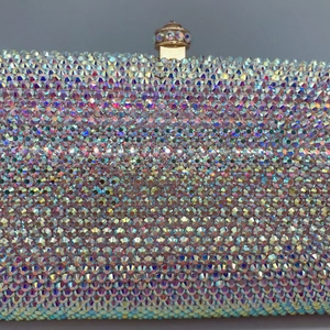 Close-up of sparkling AB colored crystals and gold metal clasp on luxury evening clutch
