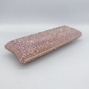 Macro shot of pink sparkling crystals and gold metal frame on an elegant dinner clutch