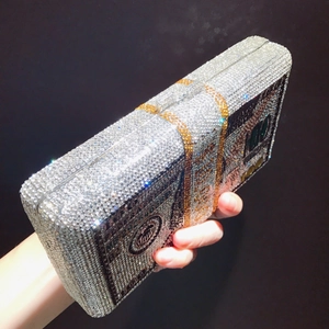 Détail latéral d'un sac pochette motif billet 100 dollars avec cristaux brillants