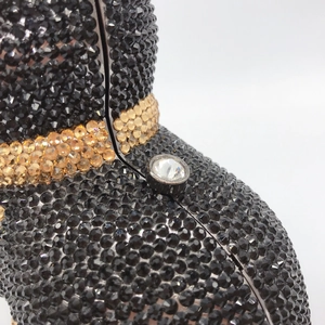 Macro shot of black and gold rhinestones with a large central diamond on a cat clutch