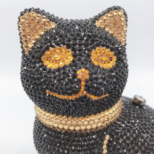Close-up of black and gold crystals on a luxury cat-shaped evening clutch bag