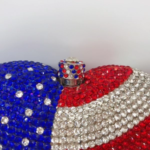 Luxurious heart-shaped American flag clutch bag with sparkling red, blue, and white crystals