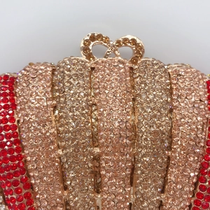 Detail of luxury evening clutch with sparkling rhinestones and heart-shaped metal clasp