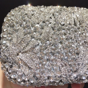 Macro shot of silver floral evening clutch with hand-set crystals and leaf details