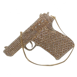Detail of a gun-shaped evening clutch bag with full rhinestones and gold-tone frame