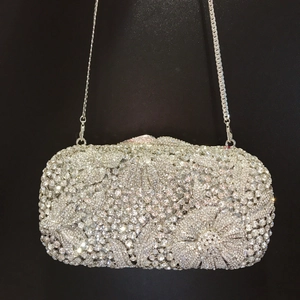 Macro detail of silver floral evening clutch bag with sparkling rhinestone encrusted patterns