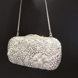 Close-up of sparkling silver floral rhinestone clutch bag with delicate metal chain strap