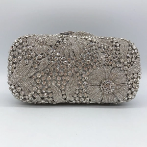 Detailed close-up of a silver floral evening clutch bag with sparkling encrusted crystals