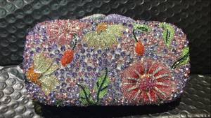 Close-up of luxury clutch with colorful floral rhinestone patterns and intricate crystal details