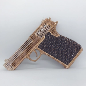Detailed view of the sparkling rhinestone pistol-shaped clutch bag with gold and black crystals
