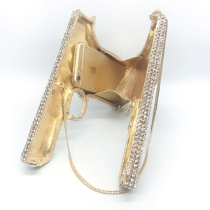 Detailed interior view of a gold pistol-shaped evening bag encrusted with sparkling crystals