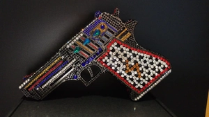 Macro view of crystal encrusted novelty gun shaped clutch bag with colorful rhinestones