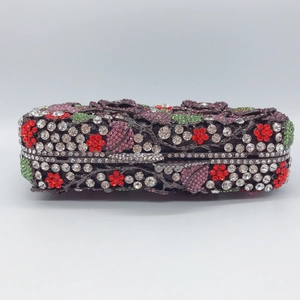 Gros plan détaillé d'une pochette à fleurs en strass avec cristaux rouges et violets