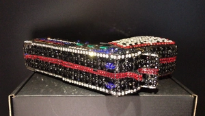 Close-up of a novelty gun-shaped evening clutch bag with sparkling multicolor rhinestones