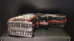 Macro shot of gun-shaped evening clutch bag with sparkling black and white rhinestones
