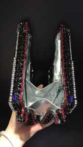 Detailed interior view of a luxury rhinestone-studded clutch with silver metallic lining