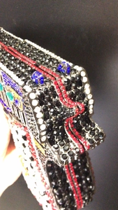 Macro shot of luxury pistol shaped clutch bag with colorful rhinestones detailing