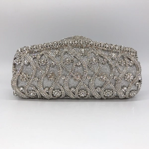 Macro detail of luxury silver evening clutch with intricate rhinestone flower patterns