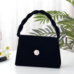 Elegant black velvet handbag with camellia pearl clasp and twisted top handle design