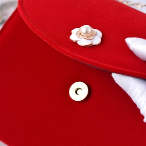 Elegant red velvet bridal clutch bag featuring camellia decoration and pearl accents