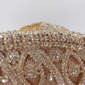 Detailed close-up of champagne gold dinner clutch featuring sparkling crystal rhinestones