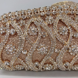 Macro detail of rose gold evening clutch featuring intricate floral rhinestone pattern