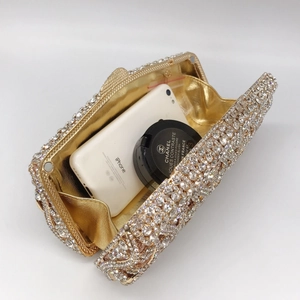 Detail showing the champagne gold interior of a rhinestone evening clutch bag with an iPhone