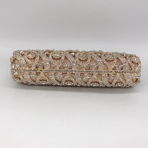 Detailed view of hollow floral metalwork and crystals on champagne evening clutch bag