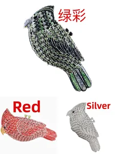 Three bird-shaped evening clutch bags with sparkling green, red, and silver rhinestones