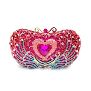 Macro detail of luxury heart evening clutch featuring multi-color crystals and gold handle